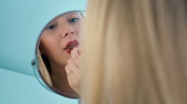 Genç bir kız evde makyaj yapıyor..