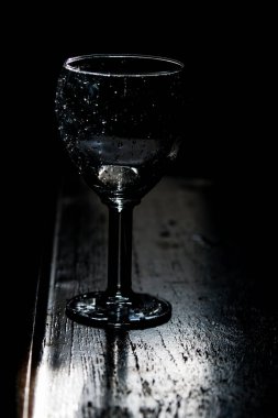 Parlayan su damlalarıyla dolu bira bardağı.