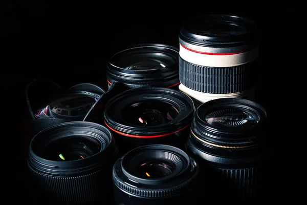 Conjunto de diferentes lentes DSLR em um fundo escuro — Fotografia de Stock