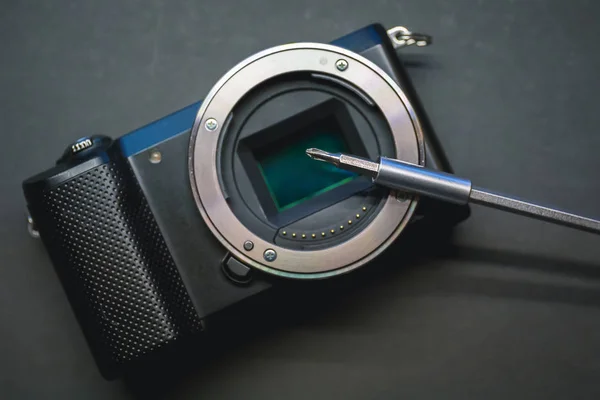Reparatur des spiegellosen Kamerasensors, Schraubendreher über Objektivfassung. — Stockfoto
