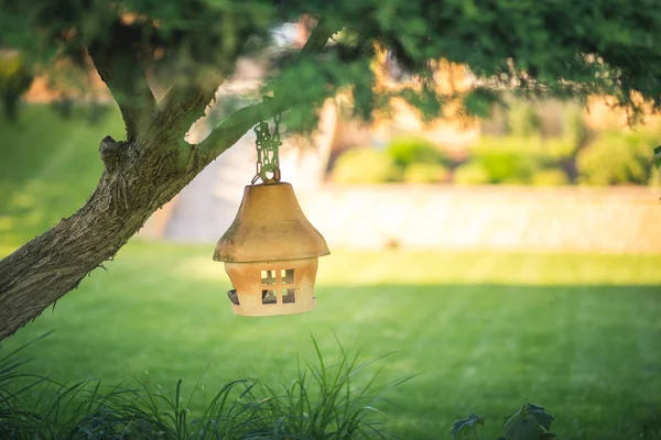 Klei of keramische Vogelvoeder opknoping op een boom in de tuin, zachte wazige achtergrond — Stockfoto