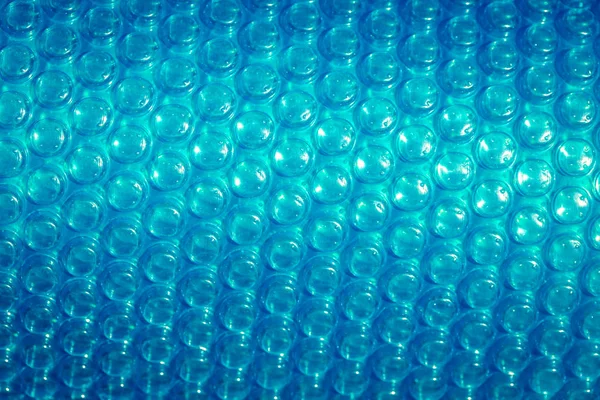 Plastic blue bubble wrap texture background, close up.