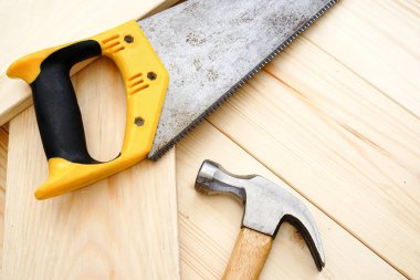 Pinewood masasında testere ve çekiç.