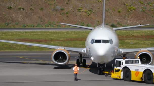 Avión tirado por un tractor. Boeing B737 en el aeropuerto de Madeira Ultra HD 4K . — Vídeo de stock