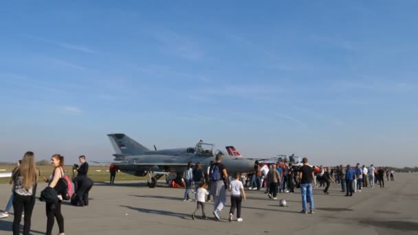 La gente cammina vicino a un jet da combattimento dell'era sovietica MiG 21 aereo militare in airshow — Video Stock