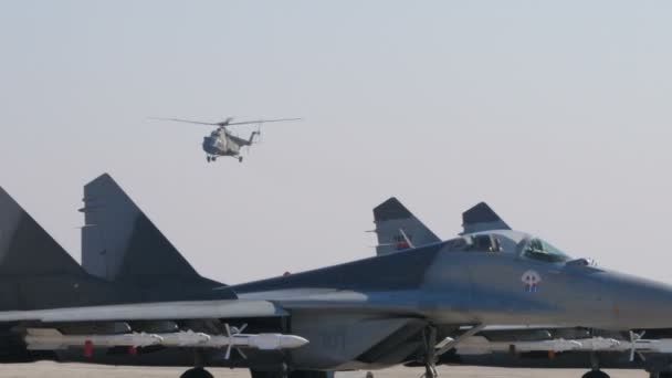 Спасательный военный вертолет Ми-17 над вооруженными боевыми самолетами МиГ-29 — стоковое видео