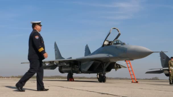 Officier en uniforme haut près d'un avion de combat militaire serbe MiG 29 Fulcrum — Video