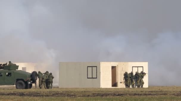 Soldati di fanteria entrano in un edificio per conquistarlo altri soldati camminano con humvee — Video Stock