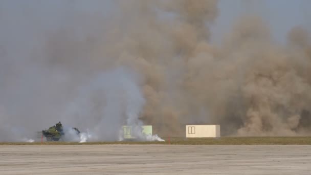 Veicolo militare armato a bordo nascosto da fumi con edifici sullo sfondo — Video Stock