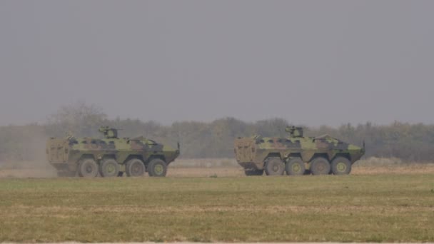 Green Mimecic Camouflage Zwaar militair voertuig met acht wielen op een veld — Stockvideo