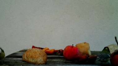 A small Bird, Great Tit - Parus Major, eat fruits and bread on a wood table