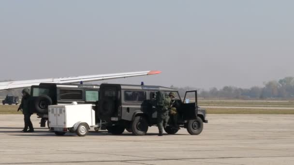 Especialista em eliminação de bombas saltar de um veículo militar off-road Land Rover Defender . — Vídeo de Stock