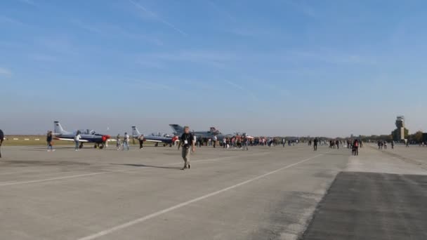 La gente cammina vicino agli aerei militari in un airshow. — Video Stock