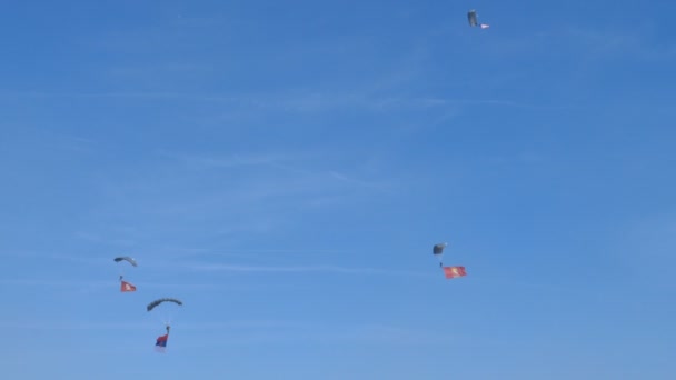 Парашутисти, парашутисти, з сербським прапором в польоті в блакитному небі під час — стокове відео