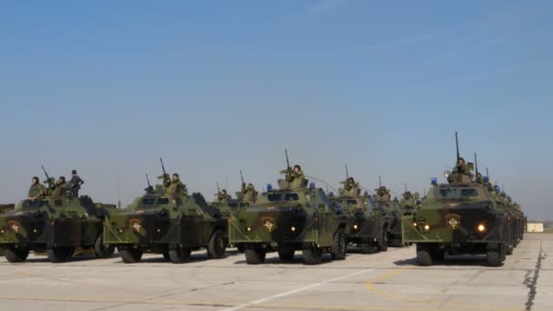 Vehículos militares blindados en camuflaje mimético verde con vuelo de paracaidistas — Vídeos de Stock