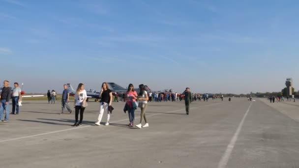 Люди ходят рядом с военными самолетами на авиашоу. — стоковое видео