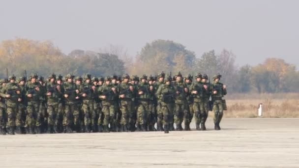 Nauwe blik op marcherende soldaten met gevechtsmaterieel van het Servische leger — Stockvideo
