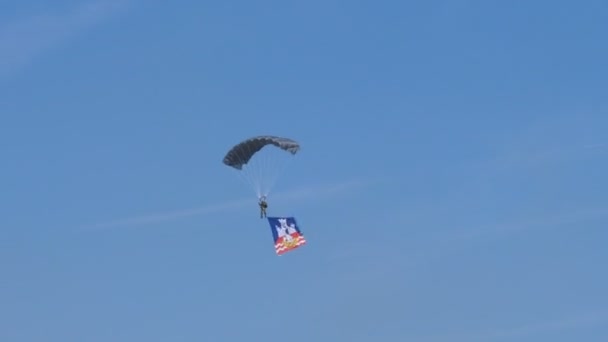 Soldat parachutiste, parachutiste, avec le drapeau de la ville de Belgrade dans un ciel bleu — Video