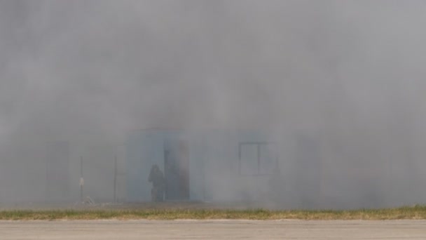 A szerb hadsereg katonái meghódítanak egy épületet, amit eltakar a füst. — Stock videók