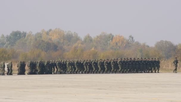 Marscherande soldater med militär utrustning i mimetisk kamouflage redo för strid — Stockvideo