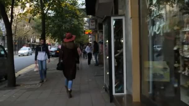 Mujer Jung con Sombrero Rojo camina en una calle comercial en el centro de la ciudad de Belgrado . — Vídeo de stock