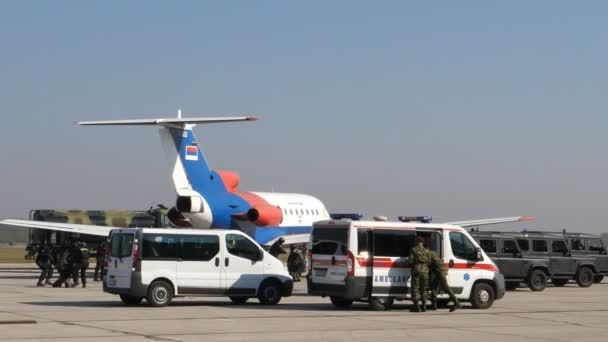 Ambulanza e veicoli di polizia circondano un aereo dirottato durante l'allenamento — Video Stock