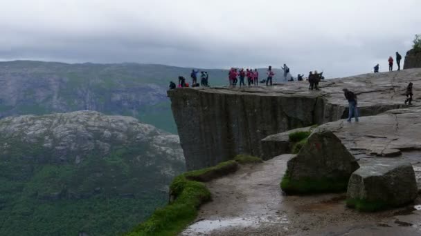 Egy csapat ember áll egy nagy szikla előtt. — Stock videók