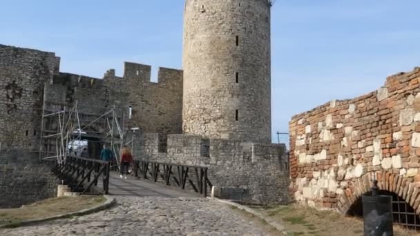 Un castillo de piedra junto a un edificio de ladrillo — Vídeos de Stock