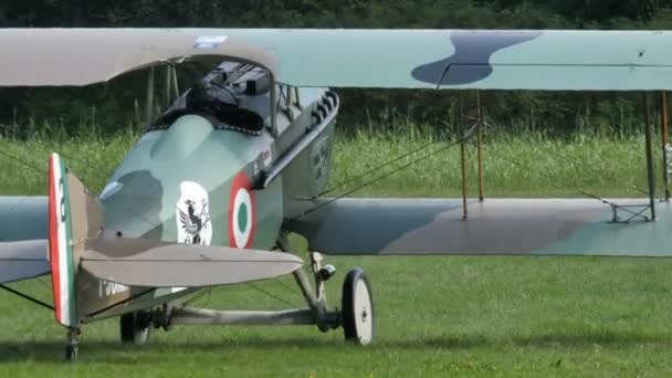 Biplan de la Première Guerre mondiale taxer dans un aérodrome d'herbe avec Ferrari cheval prancing — Video