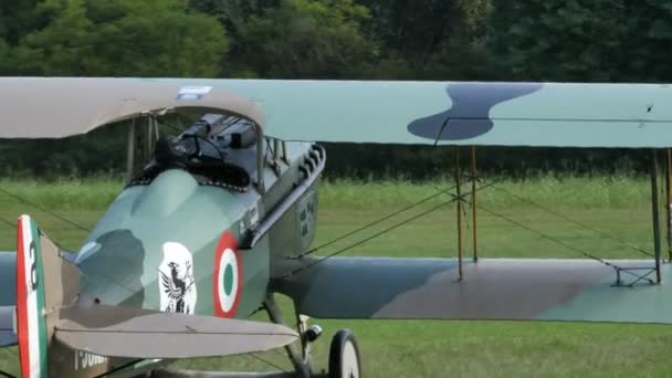 Biplan de la Première Guerre mondiale taxer dans un aérodrome d'herbe avec Ferrari cheval prancing — Video