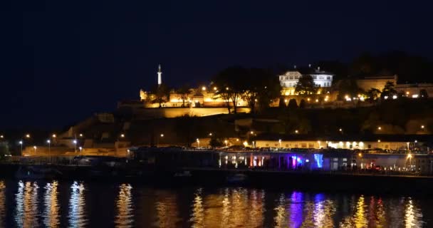 Timelapse nocturno de la fortaleza de Belgrado Kalemegdan con reflexiones ligeras sobre el río Sava — Vídeo de stock