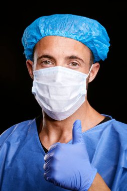 Siyah yalıtılmış arka planda mavi kağıt virüs koruma maskesi takan yakışıklı beyaz doktor portresi.