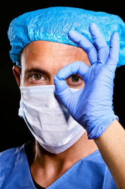 Siyah yalıtılmış arka planda mavi kağıt virüs koruma maskesi takan yakışıklı beyaz doktor portresi.