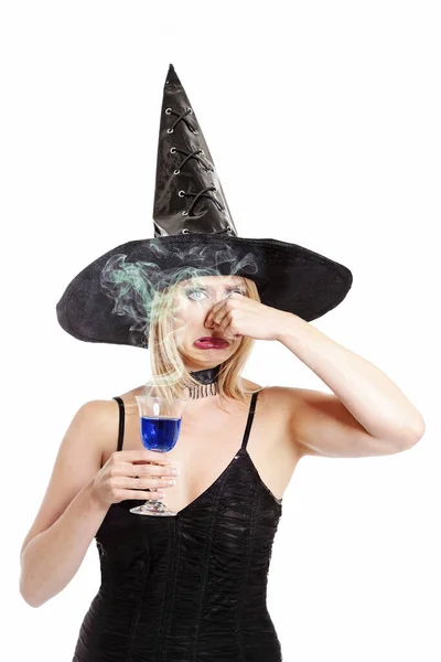 若くて可愛いですブロンド魔女女性飲む魔法のポーションのためにハロウィーンのために白い隔離された背景 — ストック写真