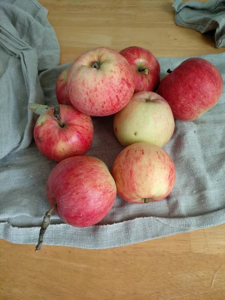 成熟的红色苹果躺在桌上的灰色亚麻布毛巾上 — 图库照片