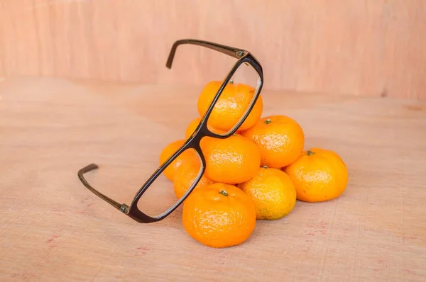 oranges and eye glasses on wooden floor