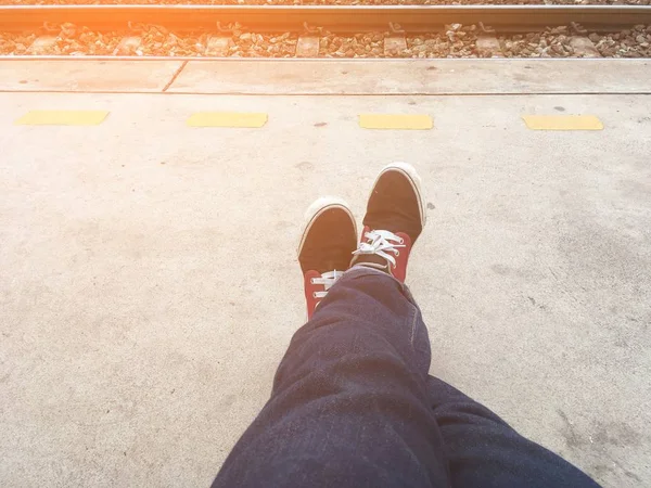 駅で鉄道の近くに座っている男の脚を閉じる — ストック写真