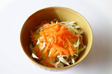 Havuçlu taze lahana salatası ve beyaz tabakta soğan.