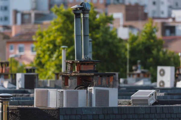 Metal bacası ve eski klimalı cihazları olan şehir silueti. Her şey eski ve terk edilmiş görünüyor.