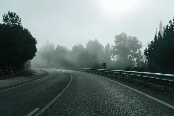 Girando Camino Solitario Amanecer Montaña Brumosa Con Una Señal Kilómetro Fotos De Stock