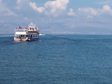 Türk iki açık güverte zevk gemisi, arka planda Yunan adası bulunan bulutlarla aydınlık bir günde Ege Denizi 'nde yelken açıyor