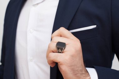 Parmaklarında gümüş yüzükler olan bir adam eli.