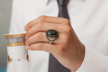 Parmaklarında gümüş yüzükler olan bir adam eli. 