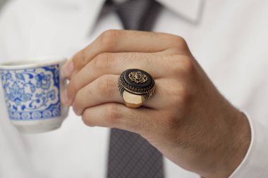 Parmaklarında gümüş yüzükler olan bir adam eli.