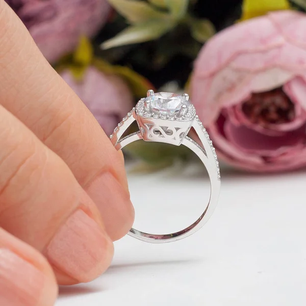 stringing jewelry on female finger polished hand on white background