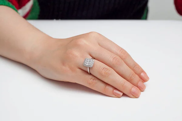 stringing jewelry on female finger polished hand on white background