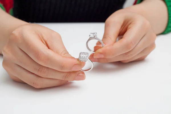 stringing jewelry on female finger polished hand on white background