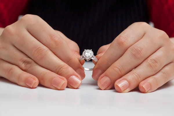 stringing jewelry on female finger polished hand on white background