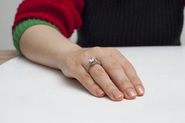 stringing jewelry on female finger polished hand on white background