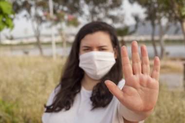 Bayan Covid-19 'dan korunmak için açık havada bir maske tarafından korunuyor. Doğal kaynaklar, ağaçlar ve temiz hava..